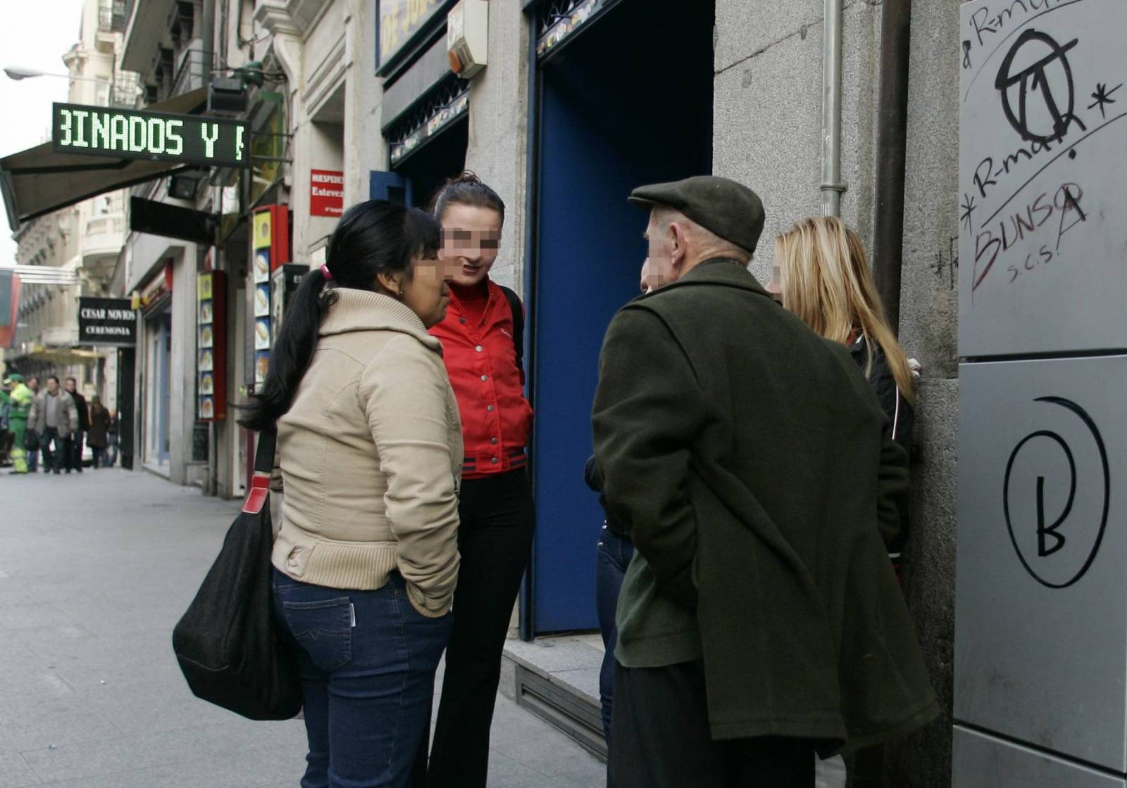 Tres prostitutas hablan con un cliente en la Calle Montera. ABC