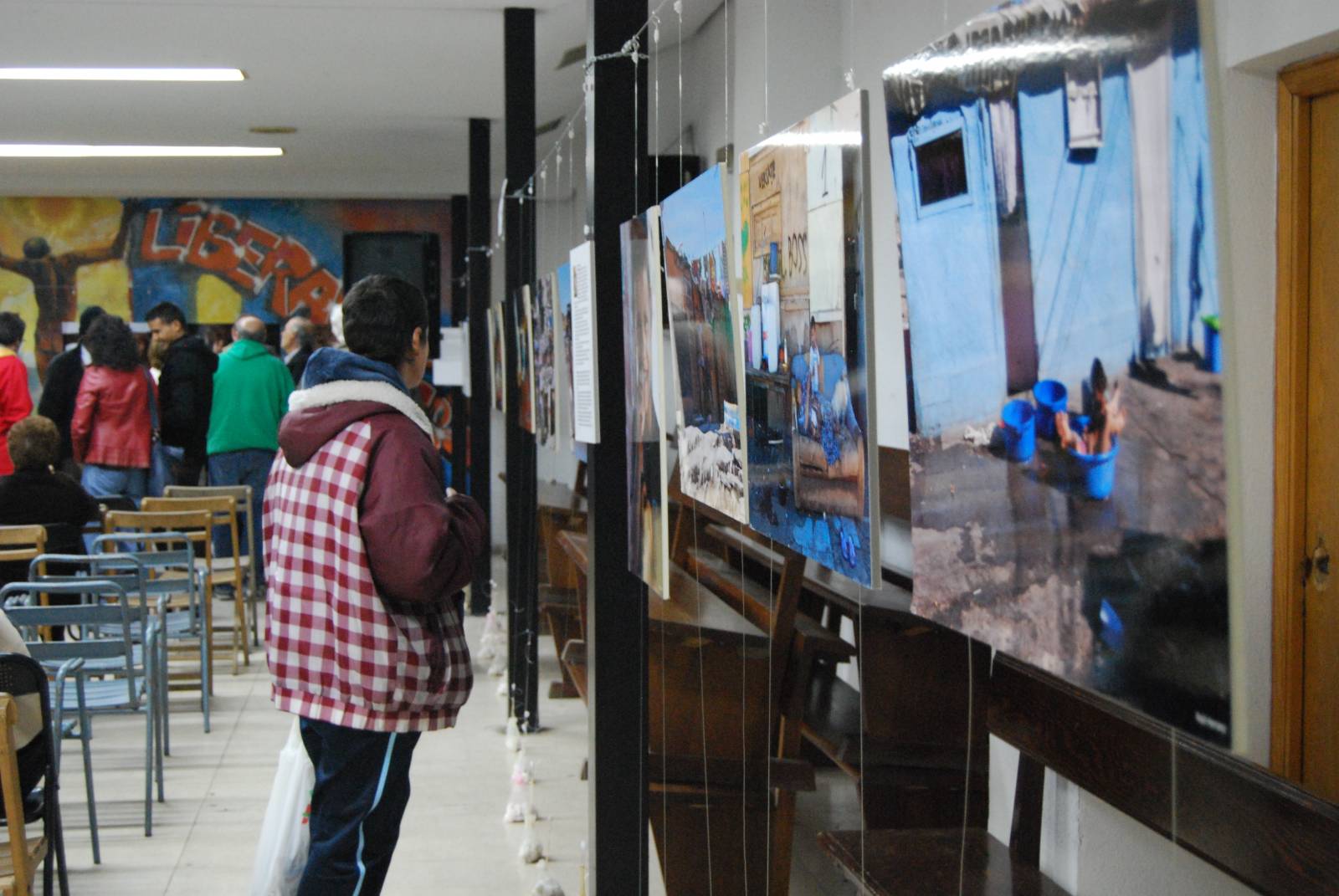 Adolescente frente a las fotografías de «Vidas al borde. Miradas al y desde El Gallinero» 