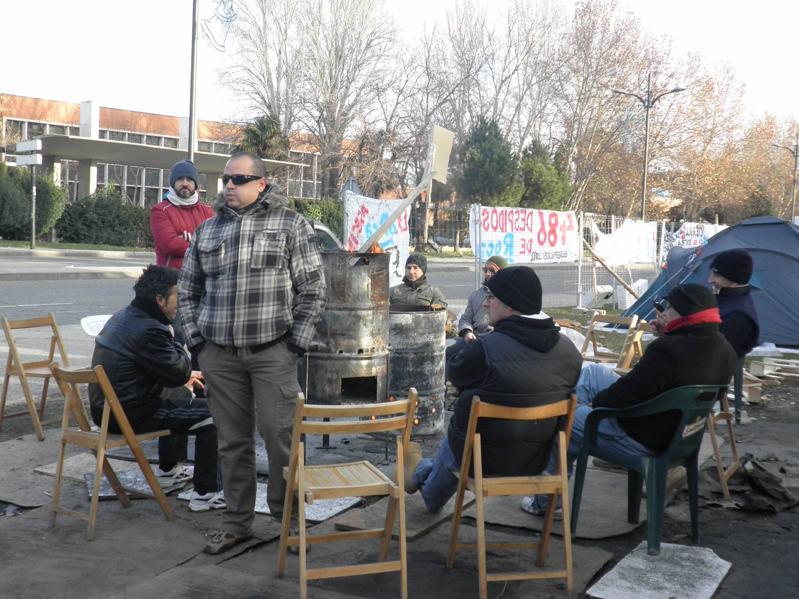 Trabajadores reunidos alrededor de la hoguera Trabajadores reunidos alrededor de la hoguera en el campamento