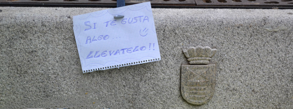 Cartel junto a un puesto del mercado de trueque de Leganés Cartel junto a un puesto del mercado de trueque de Leganés